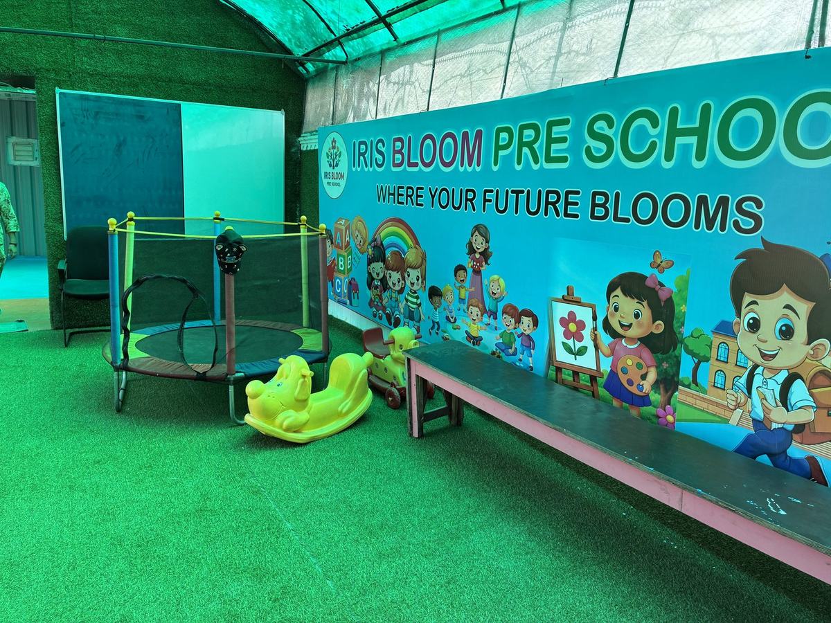 Covered play area with a trampoline, ride-on toys and the Iris Bloom Preschool brand mural