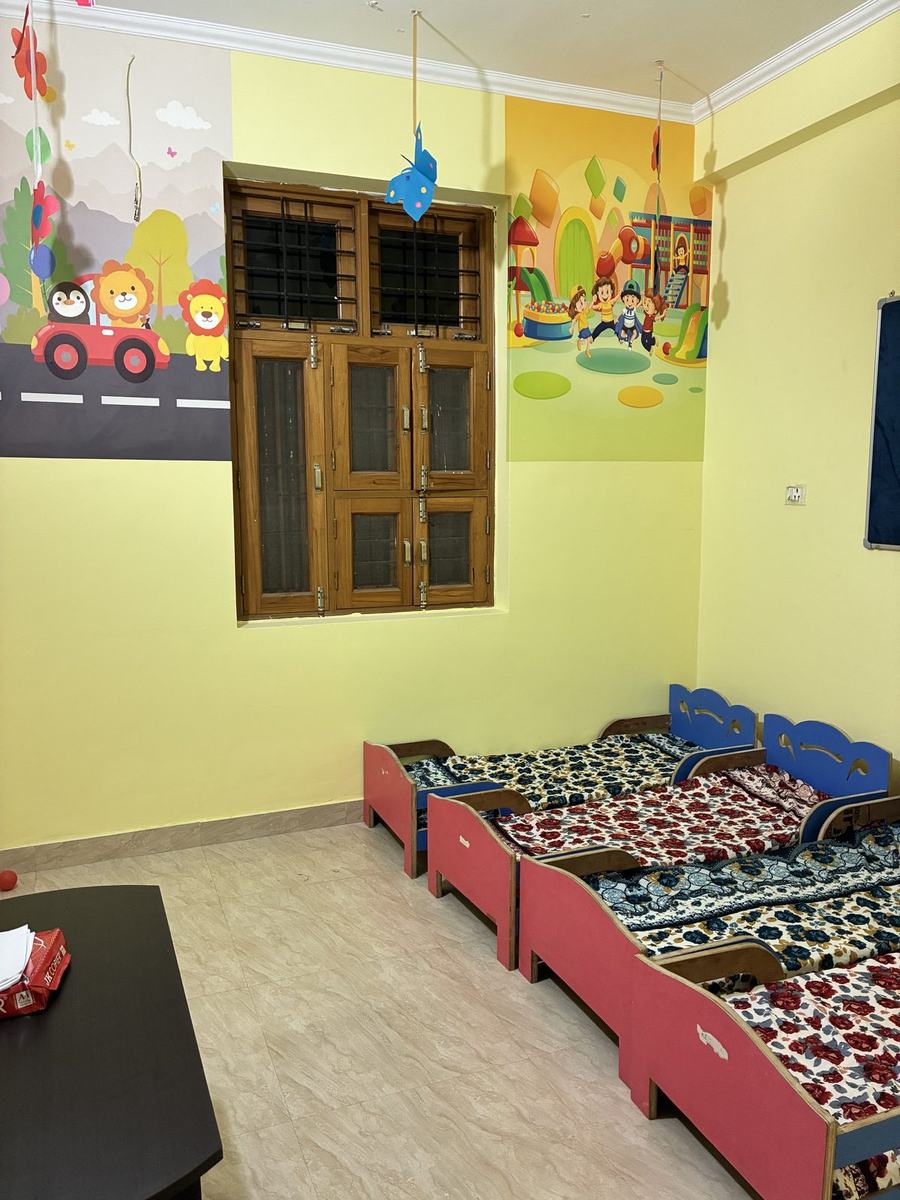 Cosy nap room with cots decorated with an animal mural